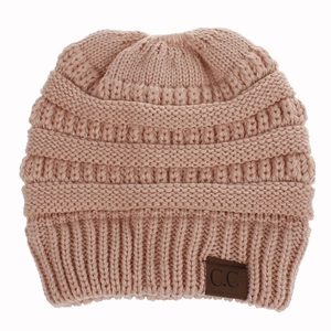 Detailed knit texture of a dusty pink ponytail beanie with a brown C.C leather patch