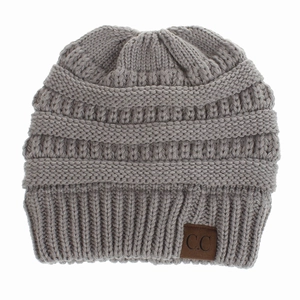 Detailed view of grey knitted beanie with textured weave and brown C.C leather patch