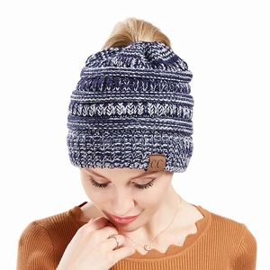 Detail of dark blue and white knit ponytail beanie with C.C logo leather patch