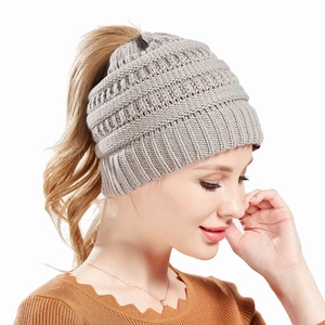 Detail of grey knitted beanie featuring a practical ponytail hole for long hair