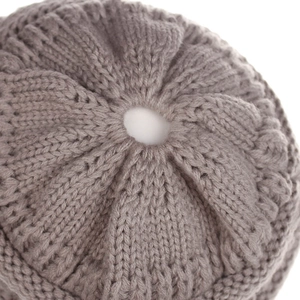 Detail of coffee brown knit beanie top with macro view of textured ponytail hole