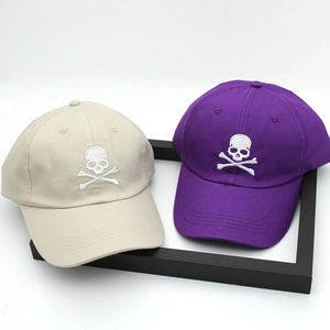 Unisex cotton baseball cap featuring embroidered skull design in beige and purple