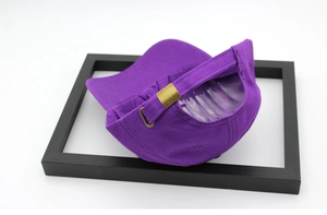Close-up of the metal buckle adjustment and stitching on a purple cotton baseball cap