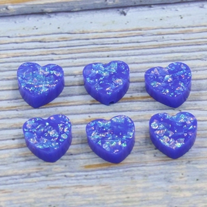 Macro shot of 12mm dark blue heart-shaped resin opal beads with glitter for DIY jewelry making
