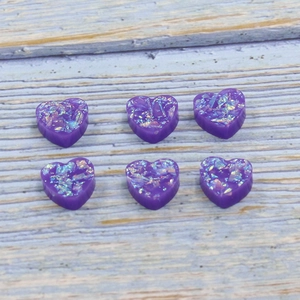 Set of 12mm purple synthetic heart-shaped opal resin charms with fire sparkles on wood