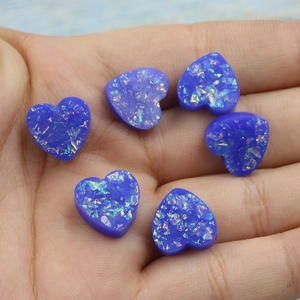 Detailed close-up of six heart-shaped blue resin opal stones with sparkling glitter finish