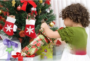 Two red felt Christmas stockings with snowflake patterns hanging as festive decorations