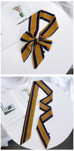 Detail showing high-quality silk scarf with yellow and blue stripes as a stylish headband