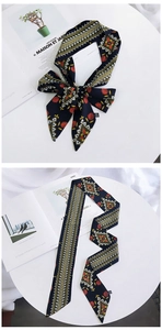 Detailed view of a long black silk scarf with red floral and ethnic geometric prints