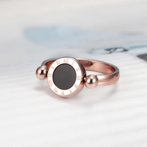 Macro shot of rose gold titanium steel ring featuring Roman numerals and black inlay