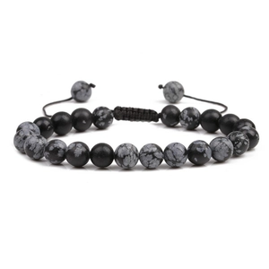 Macro view of beaded bracelet with black and spotted stones on adjustable woven cord