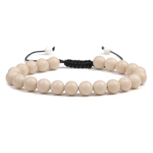 Adjustable woven bracelet featuring natural off-white round beads and a braided black cord
