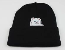 Close-up of black knit beanie featuring white character embroidery detail on front cuff