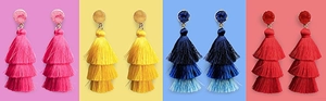 Detail view of multi-color tiered tassel earrings in pink, yellow, blue, and red silk