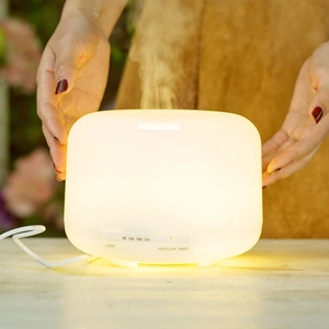 Close-up of 500ml ultrasonic aroma diffuser with mist and warm ambient lighting