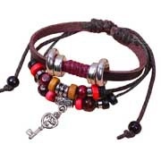 Detail of multi-layer leather bracelet featuring red wooden beads and silver key pendant