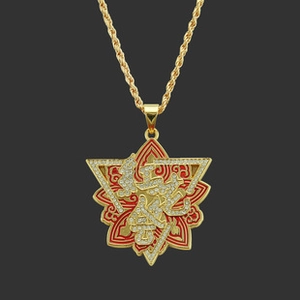 Macro detail of gold star pendant with red enamel, crystal inlay and Arabic calligraphy