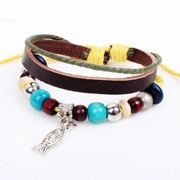 Detail of multi-layer leather bracelet with turquoise beads and silver fish charm