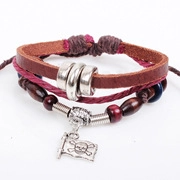 Detail of multi-layer braided leather bracelet with wood beads and skull charm
