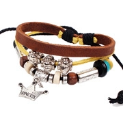 Detail of multi-layer leather bracelet featuring skull, crown pendants and wooden beads