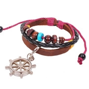 Detail shot of multilayer leather bracelet with wooden beads and metal helm charm