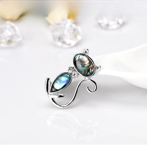 Macro shot of silver plated cat brooch featuring iridescent abalone shell and zircon stones