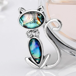 Artistic cat brooch with rainbow abalone shell inlay and crystal accents on silver metal