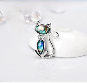 Detail of silver cat brooch with rainbow abalone shell inlay and crystal accents