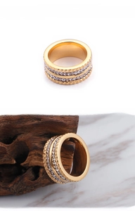Detail view of gold double-row zircon ring with unique gear-textured edges on metal band