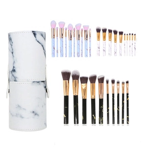 Three sets of marble handle makeup brushes with cylindrical storage holder on white background