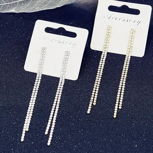 Detailed view of silver and gold long tassel rhinestone earrings on display card