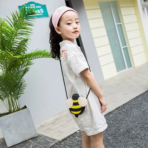 Cute bee-shaped kids crossbody bag with yellow stripes and wings worn by a child outdoors