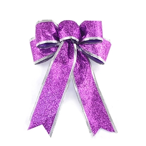 Detail of purple glitter Christmas bow with silver metallic edges and festive sparkles