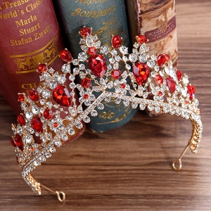 Macro detail of luxury baroque bridal crown with red water-drop rhinestones and gold metal