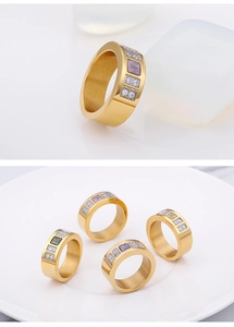 Detail of gold titanium rings with square colorful zircons and brushed metal texture