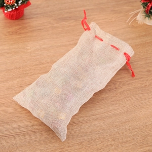 Christmas elk reindeer jute wine bottle bag with red ribbon on a rustic wooden table