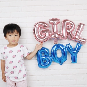 Close-up of pink GIRL and blue BOY foil balloons for baby shower party decoration