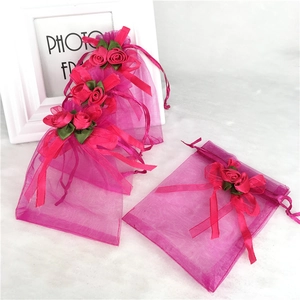Rose pink organza gift bags with drawstring closure and decorative ribbon roses