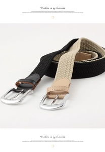 Detail of stretch woven belts in black and beige with polished silver pin buckles