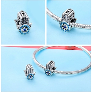 Macro shot of 925 sterling silver blue Hamsa Hand bead with sparkling crystal accents