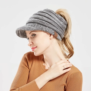 Detail of grey knitted ponytail visor hat with brown leather CC logo patch