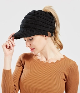 Detail of black knit ponytail beanie with CC leather logo and opening for high ponytail