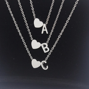 Detailed close-up of mirror polished heart puzzle and alphabet charms on black velvet