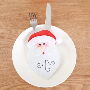 Santa Claus cutlery holder on a dinner plate for festive Christmas table decorations