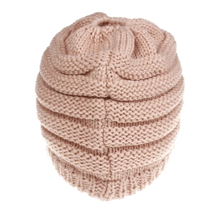 Detail of light pink chunky knit ponytail beanie with top opening and ribbed texture