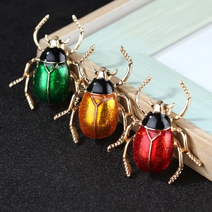 Set of 3 colorful beetle brooches with enamel finish and shimmering sequins on a gold base