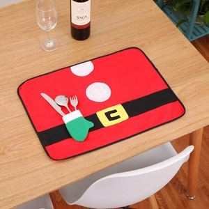 Festive Santa theme placemat with a green glove pocket for cutlery on a wooden table