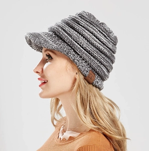 Detail of grey knitted ponytail visor beanie with C.C leather logo and ribbed texture
