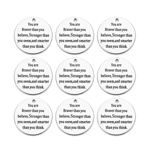 Macro shot of 9 stainless steel round charms with engraved inspirational quotes