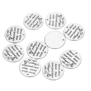 Close-up of stainless steel round pendants with engraved guardian angel quotes on white background